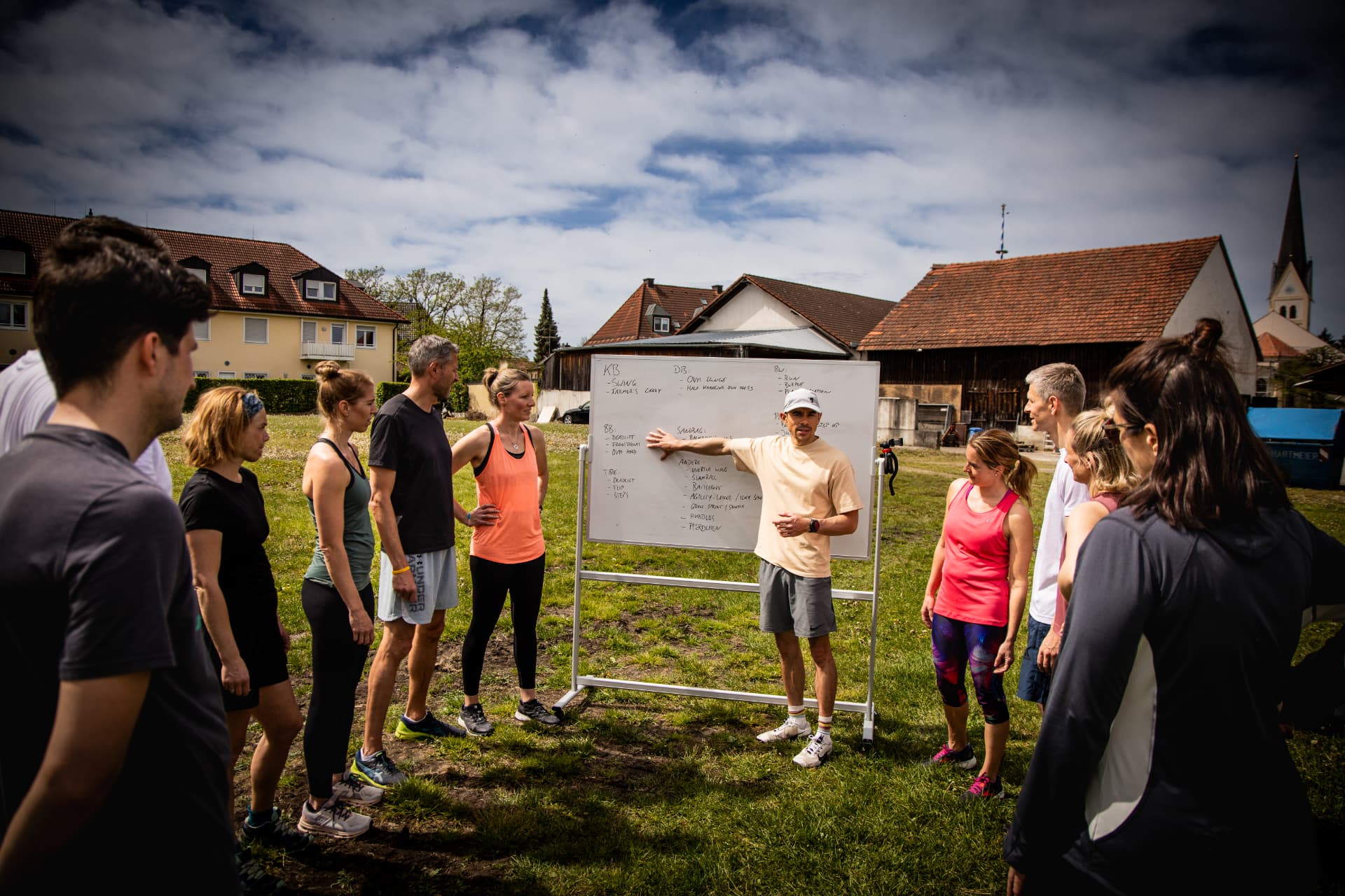 Coach erklärt der Gruppe den Trainingsplan am Whiteboard